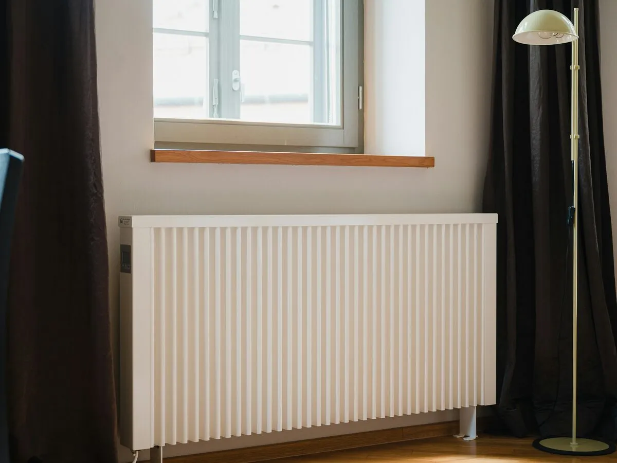 White panel radiator under a window in a living room